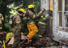 A team of Olney and Megargel Volunteer Firefighters breach the smoke-filled house. Firefighters were greeted with choking smoke and visibility reduced to one foot in some parts of the structure. The firefighters’ ability to use oxygen masks and fire-res