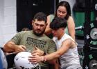 A Bobcat and his dad affix decals on the player’s helmet during the Decals with Dads event. Photo by Will Sadler