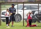 A Lady Cubs coach gives last-minute instructions to the pitcher and catcher before the game begins against the Lady Heat. Photo by Will Sadler