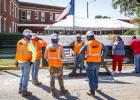 Construction crews wait as attendees at the topping off ceremony for the new Olney Hamilton Hospital sign their names to the final beam to be hung for the new building. Photo by Will Sadler