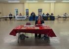 Olney Chamber of Commerce director Kimberly Smith sits at the welcome table at the first Olney Job Fair, sponsored by the Chamber and Texas Workforce Solutions. Behind her are (l-R): Avir in Olney, Tower Extrusions, Texas Dept of Criminal Justice, Air Tra