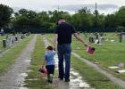 American Legion Post 414 Vice Commander Eric Loggins and his son, Tucker, place American flags on veterans’ graves at the Restland Cemetery in Olney on Memorial Day, May 26. Mr. Loggins, a U.S. Marine veteran, and Tucker joined a couple dozen volunteers