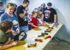 Cub Scouts and attendees check out all the Pinewood Derby cars that will be raced in the night’s event. Photo by Will Sadler