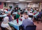Revelers at the Olney Senior Cub Center gather to wish Edwana Fikes a happy retirement and thanks for her 20 years working the telephones and the desk and serving meals. Photo by Will Sadler