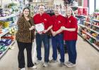 Olney Chamber of Commerce director Kimberly Smith hands a certificate to Jeff, Rand and Kris Kamp honoring ACE Hardware’s first anniversary. Photo by Will Sadler