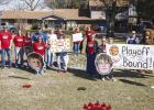 Parents, fans, and community members lined the road with signs and cheering as the Cubs rode past, heading to the Bi-District playoff game. Photo by Will Sadler