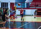 Attendees of the basketball camp practice passing as they race back and forth on the court passing the ball as they go. Photo by Will Sadler