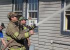 Olney Firefighter Jason Pack mans a hose during a house fire near the Young County/Archer County border.